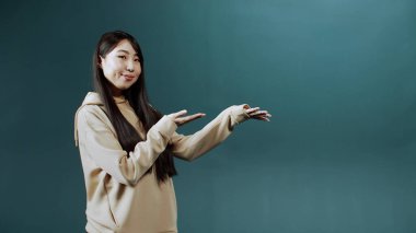 Yakışıklı Asyalı bir bayan ürününün reklamını yapıyor.