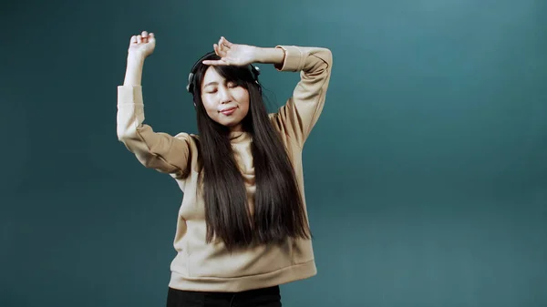 Chica divertida positiva con el pelo largo y oscuro bailando solo, moviéndose a la música favorita, disfrutando del tiempo libre — Foto de Stock