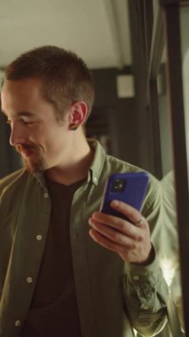 Genç düşünceli bir erkek öğrenci pencerenin yanında duruyor, kafasını çeviriyor ve bazı önemli detayları hatırlıyor. Yüksek kaliteli FullHD görüntüler