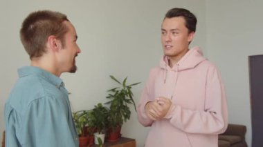 İki Igbt adamı oturma odasında yan yana duruyorlar ve birbirleriyle konuşuyorlar, yakın çekim. Yüksek kaliteli FullHD görüntüler