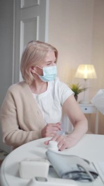 Doktor aşıyı teslim etmek için hastaların evine geldi. Koruyucu giysili bir hademe şırıngaya aşı çeker ve iğne yapmaya hazırlanır. Yüksek kaliteli FullHD görüntüler