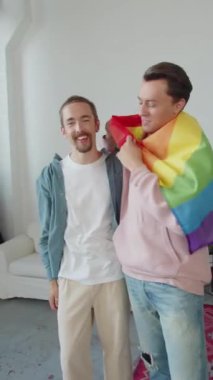 Igbt bayrağıyla kaplanmış iki genç adam yan yana duruyor ve kameraya bakın. Yüksek kaliteli FullHD görüntüler