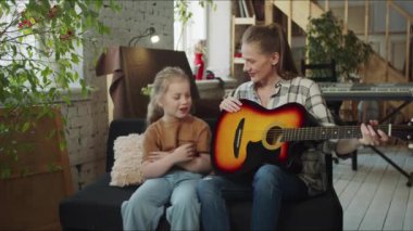 Çocuk gitar çalmayı istemiyordu. Kavga eder ve gitarı annesine verir. Yüksek kalite 4k görüntü