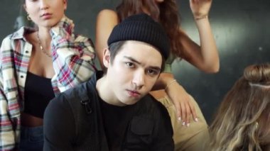 Ciddi bakışlı adam oturuyor ve etrafında güzel kızlar kalıyor. Yüksek kalite 4k görüntü