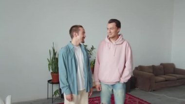 İki yakışıklı Igbt erkeği salonun ortasında birlikte duruyorlar ve birbirleriyle konuşuyorlar. Yüksek kaliteli FullHD görüntüler