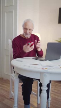 Bir emekli geniş bir odada bir sandalyeye oturur. Bir video görüşmesinde biriyle konuşuyor. Yüksek kaliteli FullHD görüntüler