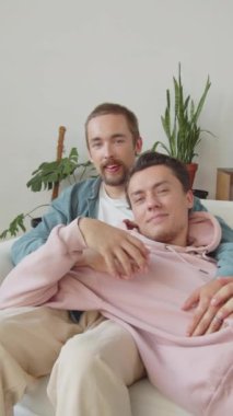 LGBT çifti kanepede birlikte oturup eğleniyorlar. Yüksek kaliteli FullHD görüntüler