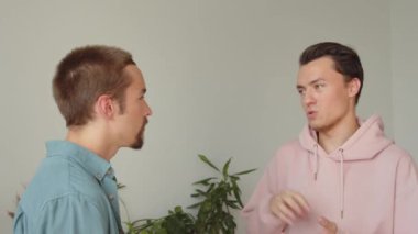 İki Igbt adamı oturma odasında yan yana duruyorlar ve birbirleriyle konuşuyorlar, yakın çekim. Yüksek kaliteli FullHD görüntüler