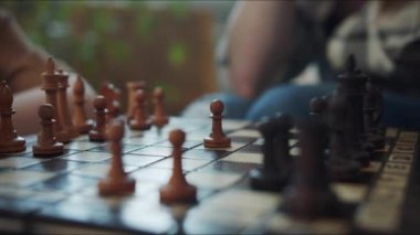 Çocuk satranç oynuyor. Rakiplerinin maçını seyrediyor ve bir piyonu iki kare ileriye götürüyor. Yakın çekim, yüksek kalite 4K görüntü