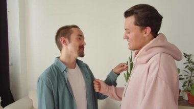 Eğlenceli sohbetler sırasında, yan yana dururken, iki genç lgbt erkeği birbirine dokunuyor. Yüksek kaliteli FullHD görüntüler