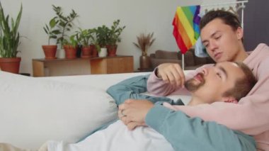İki Igbt adamı kanepede uzanıp birbirlerine bakıyorlar ve konuşuyorlar. Yüksek kalite 4k görüntü