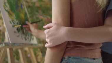 Stüdyoda, iki kız arkadaş yeşilin tonlarında bir resim çiziyor, yakın çekim. Yüksek kaliteli FullHD görüntüler