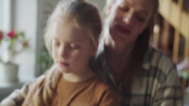 Bir kadın kızının arkasında duruyor ve onunla birlikte elektronik piyano çalıyor. Sevinirler ve gülümserler. Yüksek kalite 4k görüntü