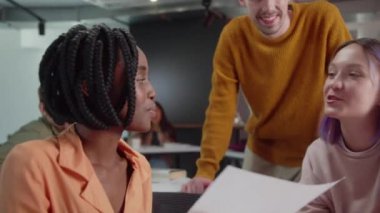 Enerjik genç öğrenciler üniversitede mola sırasında öğretmenleriyle konuşuyor ve gülümsüyorlar, yavaş çekimde yaklaşıyorlar. Yüksek kalite 4k görüntü