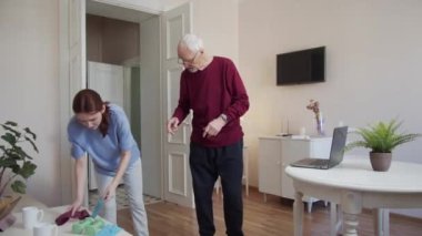 Bir kadın yaşlı müşterisine fitness bandını nasıl kullanacağını gösterir. Elleriyle esnetiyorlar. Yüksek kalite 4k görüntü