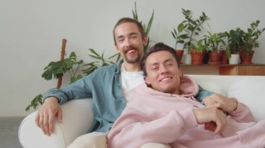 LGBT çifti kanepede birlikte oturup eğleniyorlar. Yüksek kaliteli FullHD görüntüler