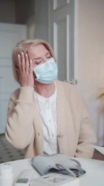 Genç bir bayan doktor yaşlı bir hastayı muayene etmeye geldi. Kadın baş ağrısı olduğunu söylüyor ve yardım istiyor. Doktor tablete belirtileri yazıyor ve teşhis koyuyor.