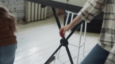 Bir kadın bir kızla oynuyor. Elektronik piyanonun etrafında koşup birbirlerini yakalamaya çalışıyorlar. Yüksek kalite 4k görüntü