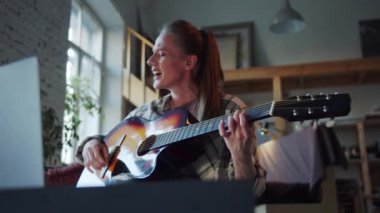 Yetişkin bir kadın arkadaşlarıyla video aracılığıyla iletişim kurar. Şarkı söyler ve gitar çalar. Yüksek kalite 4k görüntü