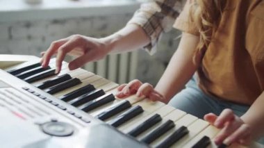 Sert bir öğretmen müzik dersinde bir çocuğa yardım eder. Arkasından yaklaşıp kızla oynamaya başladı. Yüksek kalite 4k görüntü