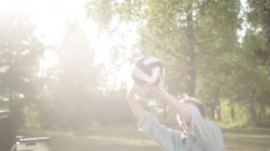 Genç Asyalı bir bayan ve engelli erkek arkadaşı halk parkında voleybol oynuyorlar. Yüksek kalite 4k görüntü