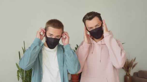 Jóvenes Hombres Lgbt Están Pie Mirando Cámara Poniendo Máscaras Protectoras — Vídeo de stock