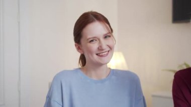 Mavi gömlekli ve at kuyruklu bir kadın kameraya bakar ve tatlı tatlı gülümser. Yaşlı ve gözlüklü babası yakınlarda oturuyor ve huzur içinde gülüyor. Yüksek kalite 4k görüntü