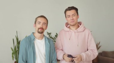 İki tatlı Igbt adamı ayakta duruyor. Kameraya bakıyor ve koruyucu maskeler takıyordu. Yüksek kalite 4k görüntü