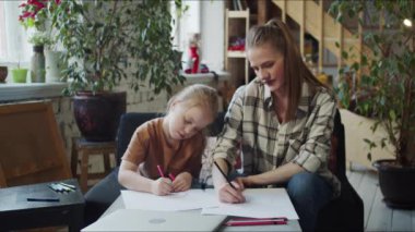 Bekar bir anne boş zamanını çocuğuyla geçirir. Bir kadın çizer ve kızının çizdiklerine bakar. Yüksek kalite 4k görüntü