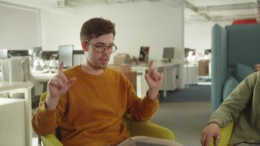 Üniversitede dinlenme yerinde oturan iki genç öğrenci, yavaş çekimde projeyi tartışıyorlar. Yüksek kaliteli FullHD görüntüler