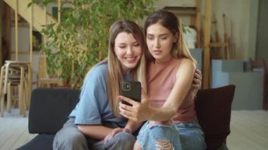 İki genç bayan video görüşmesinde arkadaşlarıyla konuşmayı bitirdiler, el sallayıp öpücük gönderdiler. Yüksek kaliteli FullHD görüntüler