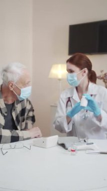 Hastaların evinde hijyenik. Beyaz önlüklü bir kadın dedeme hapların paketlenmesinden bahsediyor. Yüksek kaliteli FullHD görüntüler