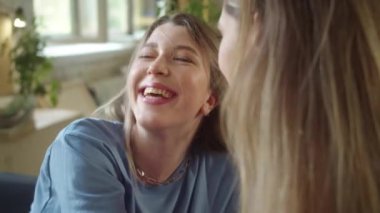 İki genç ve güzel bayan birlikte oturuyorlar, sarılıyorlar ve eğleniyorlar. Yüksek kaliteli FullHD görüntüler