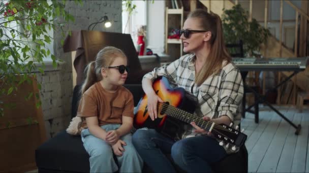Äiti Viihdyttää Tytärtään Soittamalla Kitaraa Käyttävät Mustia Laseja Käyttäytyvät Kuin — kuvapankkivideo