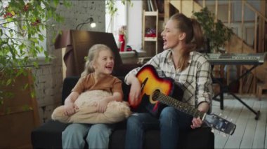 Müzik öğretmeni özellikle gitar çalar ve genç öğrencisiyle şarkı söyler. Yüksek kalite 4k görüntü