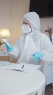 Doktorun muayenehanesindeki yaşlı kadın. Kadın bir doktor onu muayene eder ve ateşini ölçer. Sonra da ölçümleri hastaya gösterir. Yüksek kaliteli FullHD görüntüler