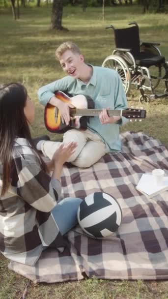 Ung Handikappad Man Med Gitarr Handen Sitter Pläden Och Sjunger — Stockvideo