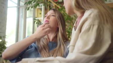 LGBT kadınları oturma odasında birlikte oturur, birbirleriyle konuşur, gülümserler ve bir tanesi kız arkadaşının saçına dokunur. Yüksek kaliteli FullHD görüntüler