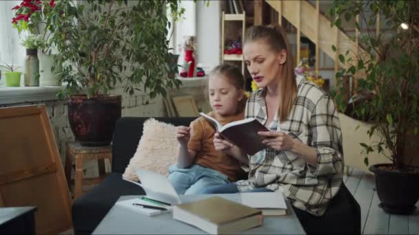 Das Kindermädchen Liest Dem Kind Ein Buch Vor Und Hilft — Stockvideo