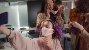 Beş öğrenciden oluşan bir grup birlikte komik fotoğraflar çekiyorlar, üniversitede konferans salonunda, yavaş çekimde. Yüksek kalite 4k görüntü