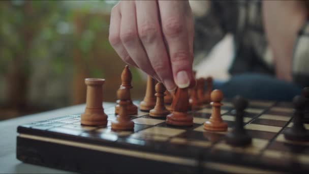 一个女人解决了一个与国际象棋有关的逻辑问题 她在棋盘上排列棋子 高质量的4K镜头 — 图库视频影像