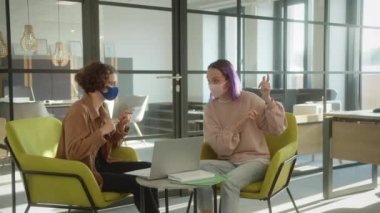 Mola sırasında dinlenme alanında oturan iki kız öğrenci, projeleri hakkında ağır çekimde tartışıyorlar. Yüksek kalite 4k görüntü