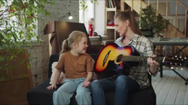 Bir kadın bir çocuktan gitar çalma pratiği yapmasını ister. Kız gitarı itiyor ve reddediyor. Yüksek kalite 4k görüntü