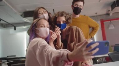 Neşeli sınıf arkadaşları birlikte komik fotoğraflar çekiyorlar, seyircilerin arasında oturuyorlar. Yüksek kalite 4k görüntü