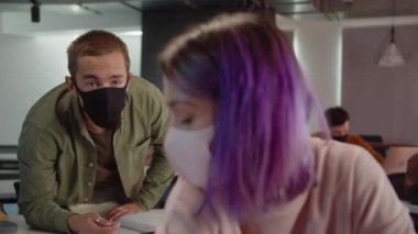 Sınıfta oturan genç ve çekici bir öğrenci semineri dinliyor ve yavaş çekimde bir sınav ödevi yazıyor. Yüksek kalite 4k görüntü