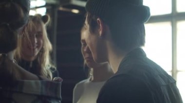 Genç adam ve üç kız stüdyoda ayakta iletişim kuruyor. Yüksek kalite 4k görüntü