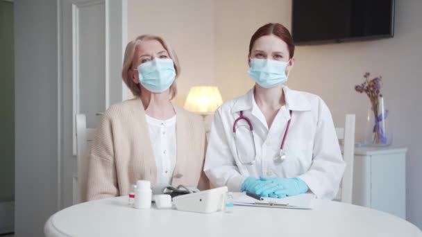 Doktor Starší Pacient Sedí Stolu Dívají Kamery Mají Tvářích Masky — Stock video