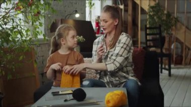 Çocuk bir eşarp örmeyi öğreten annesini dinler. Yüksek kalite 4k görüntü