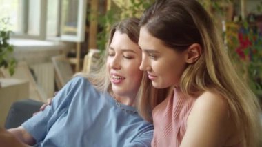İki genç ve güzel bayan internette dizüstü bilgisayarlarını araştırıyor, tartışıyor ve gülümsüyorlar. Yüksek kaliteli FullHD görüntüler