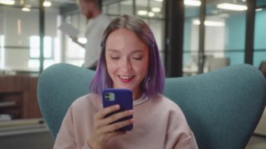 Genç, sevimli bir öğrenci sandalyede oturur ve internette komik yazılar okur, yavaş çekimde kapatır. Yüksek kaliteli FullHD görüntüler